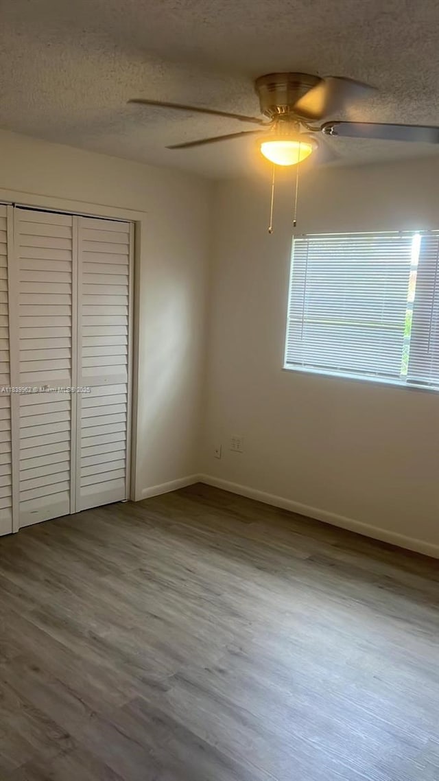 7230 NW 3rd St, Miami, FL 33126 - unfurnished bedroom with a textured ceiling, a closet, wood finished floors, and ceiling fan