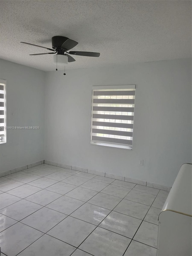 305 NW Opa Locka Blvd, North Miami, FL 33168 - empty room featuring a textured ceiling, tile patterned floors, and a ceiling fan