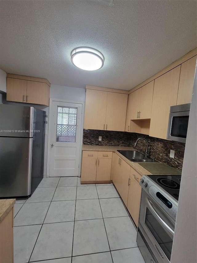 305 NW Opa Locka Blvd, North Miami, FL 33168 - kitchen with appliances with stainless steel finishes, light brown cabinets, backsplash, a textured ceiling, and light tile patterned floors