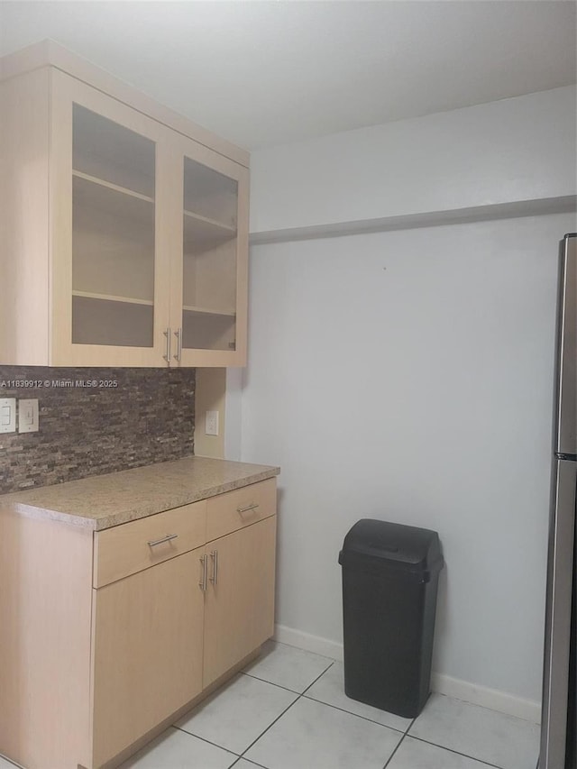 305 NW Opa Locka Blvd, North Miami, FL 33168 - kitchen featuring decorative backsplash, light tile patterned floors, light countertops, and glass insert cabinets