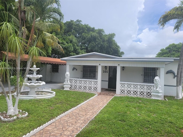 305 NW Opa Locka Blvd, North Miami, FL 33168 - view of front of property with a porch, a front lawn, and stucco siding