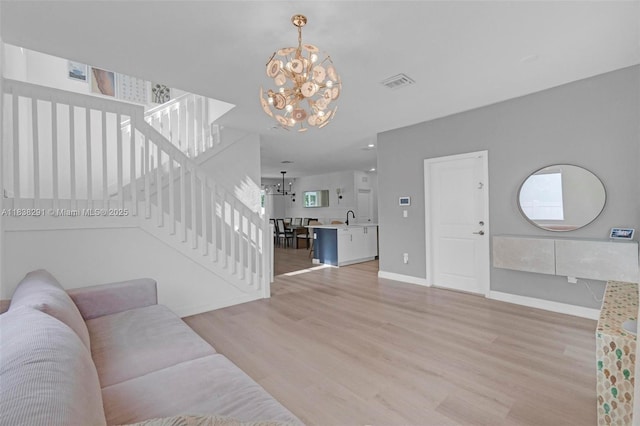 14864 SW 163rd Ter, Miami, FL 33187 - living room featuring a chandelier, stairway, and light wood-style flooring