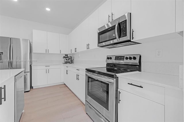 14864 SW 163rd Ter, Miami, FL 33187 - kitchen featuring stainless steel appliances, light countertops, recessed lighting, white cabinets, and light wood-style floors