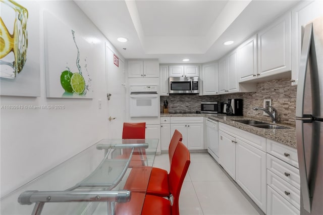 3901 S Ocean Dr Unit 10C, Hollywood, FL 33019 - kitchen featuring appliances with stainless steel finishes, backsplash, light tile patterned floors, white cabinets, and recessed lighting