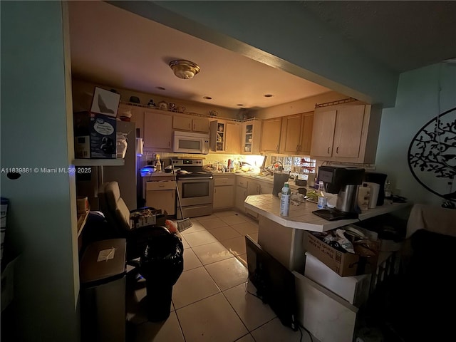 6550 SW 56th St, Davie, FL 33314 - kitchen with white microwave, stainless steel electric range, light tile patterned floors, glass insert cabinets, and tile countertops