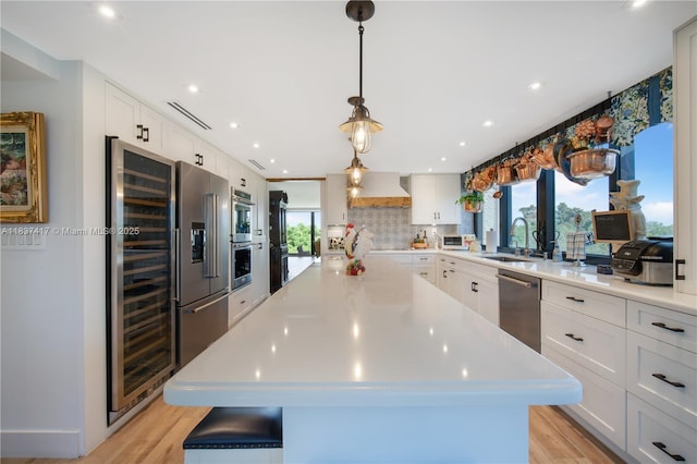 700 Coral Way Unit 4, Coral Gables, FL 33134 - kitchen featuring stainless steel appliances, wine cooler, light countertops, white cabinets, and recessed lighting