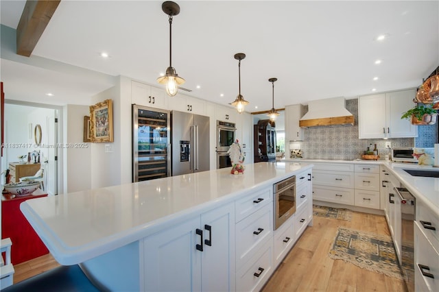 700 Coral Way Unit 4, Coral Gables, FL 33134 - kitchen featuring premium range hood, stainless steel appliances, beverage cooler, a kitchen island, and decorative backsplash