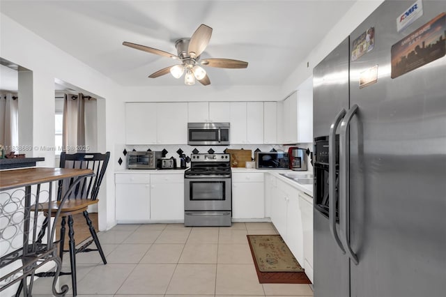 500 S Luna Ct Unit 6, Hollywood, FL 33021 - kitchen with appliances with stainless steel finishes, tasteful backsplash, a ceiling fan, light countertops, and white cabinets
