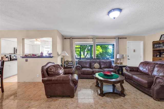 500 S Luna Ct Unit 6, Hollywood, FL 33021 - living area featuring a textured ceiling, light tile patterned floors, and a ceiling fan