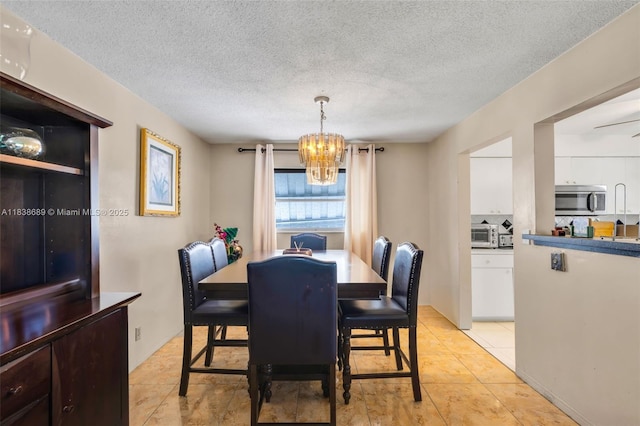 500 S Luna Ct Unit 6, Hollywood, FL 33021 - dining space featuring a chandelier, a textured ceiling, and light tile patterned floors