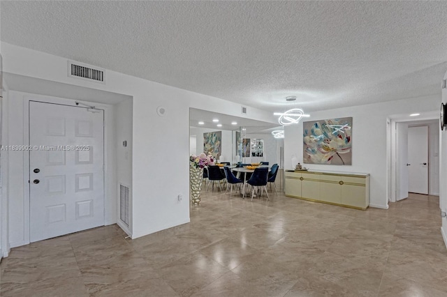 1201 S Ocean Dr Unit 904N, Hollywood, FL 33019 - foyer with a textured ceiling, light marble finish flooring, and a chandelier