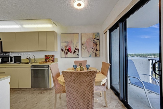 1201 S Ocean Dr Unit 904N, Hollywood, FL 33019 - kitchen with stainless steel appliances, cream cabinets, a textured ceiling, light countertops, and light marble finish floors