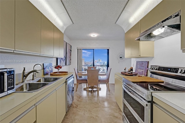 1201 S Ocean Dr Unit 904N, Hollywood, FL 33019 - kitchen featuring appliances with stainless steel finishes, under cabinet range hood, light countertops, cream cabinetry, and a textured ceiling