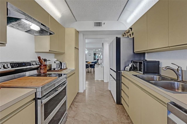 1201 S Ocean Dr Unit 904N, Hollywood, FL 33019 - kitchen featuring appliances with stainless steel finishes, cream cabinetry, exhaust hood, light countertops, and a textured ceiling