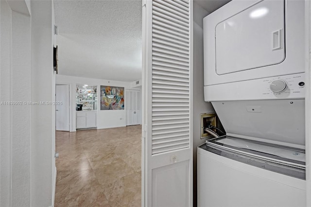 1201 S Ocean Dr Unit 904N, Hollywood, FL 33019 - washroom with stacked washing machine and dryer and a textured ceiling