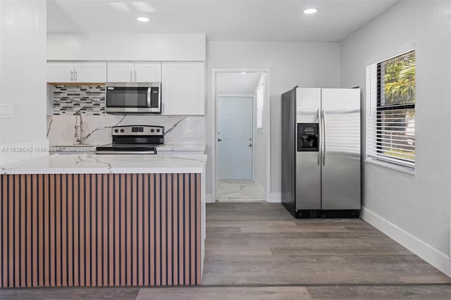 15900 NW 18th Ave, Miami Gardens, FL 33054 - kitchen featuring appliances with stainless steel finishes, white cabinetry, light stone countertops, tasteful backsplash, and recessed lighting