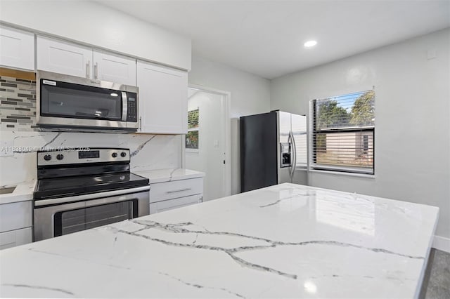 15900 NW 18th Ave, Miami Gardens, FL 33054 - kitchen featuring appliances with stainless steel finishes, healthy amount of natural light, white cabinets, light stone counters, and recessed lighting