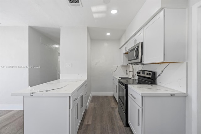 15900 NW 18th Ave, Miami Gardens, FL 33054 - kitchen featuring appliances with stainless steel finishes, a peninsula, dark wood finished floors, white cabinetry, and light stone counters