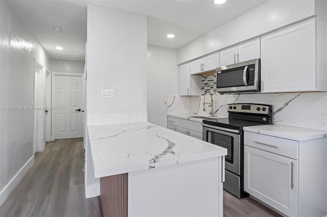 15900 NW 18th Ave, Miami Gardens, FL 33054 - kitchen featuring appliances with stainless steel finishes, dark wood finished floors, white cabinets, light stone counters, and recessed lighting