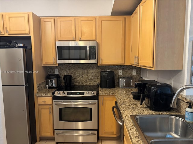 6001 SW 70th St Unit 304, South Miami, FL 33143 - kitchen with stainless steel appliances, light stone counters, and backsplash