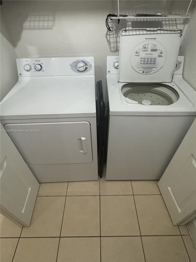 6001 SW 70th St Unit 304, South Miami, FL 33143 - laundry area featuring washing machine and clothes dryer and tile patterned floors