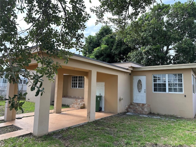 658 SE 8th Pl, Hialeah, FL 33010 - view of front of property featuring entry steps, stucco siding, a patio, and a front yard