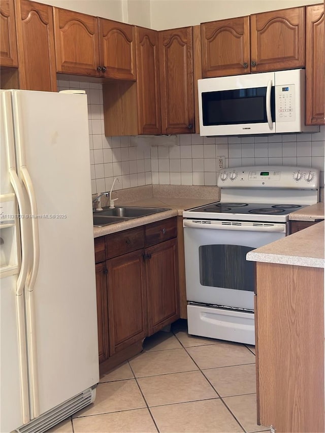 658 SE 8th Pl, Hialeah, FL 33010 - kitchen featuring white appliances, tasteful backsplash, light tile patterned flooring, and light countertops
