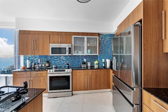 325 S Biscayne Blvd Unit 1823, Miami, FL 33131 - kitchen with appliances with stainless steel finishes, dark stone counters, and brown cabinetry