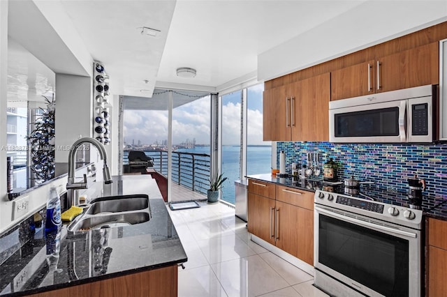 325 S Biscayne Blvd Unit 1823, Miami, FL 33131 - kitchen featuring stainless steel appliances, brown cabinets, dark stone countertops, a water view, and decorative backsplash