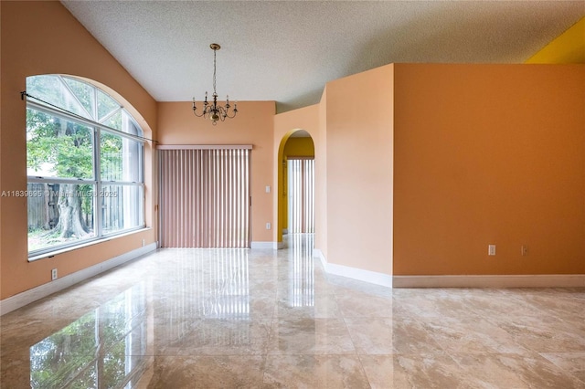 14677 SW 123rd Ave, Miami, FL 33186 - empty room featuring arched walkways, marble tiled floors, a chandelier, and a textured ceiling