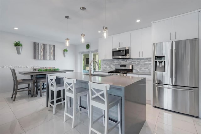 11940 NW 33rd St, Sunrise, FL 33323 - kitchen featuring appliances with stainless steel finishes, tasteful backsplash, recessed lighting, a breakfast bar, and a center island with sink