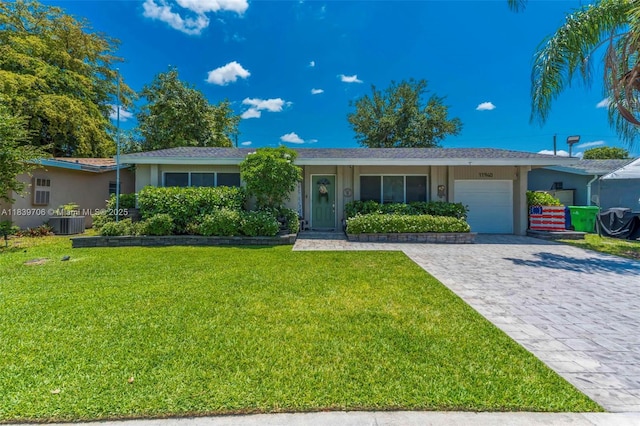 11940 NW 33rd St, Sunrise, FL 33323 - single story home with an attached garage, a front lawn, stucco siding, and decorative driveway