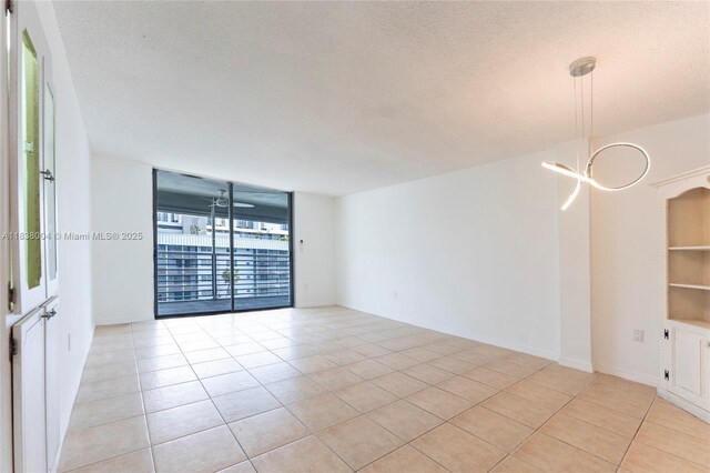 3551 NE 169th St Unit 411, North Miami Beach, FL 33160 - spare room with light tile patterned flooring and a textured ceiling