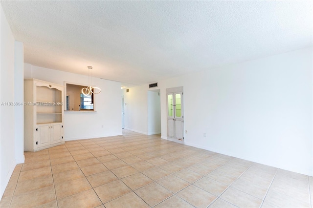3551 NE 169th St Unit 411, North Miami Beach, FL 33160 - spare room with a textured ceiling, light tile patterned flooring, and a chandelier