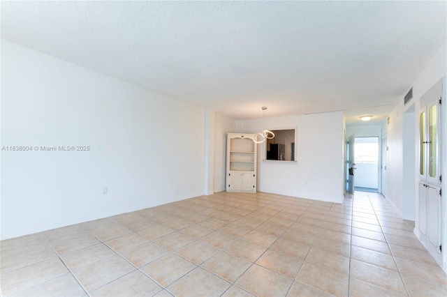 3551 NE 169th St Unit 411, North Miami Beach, FL 33160 - empty room with light tile patterned floors and a textured ceiling