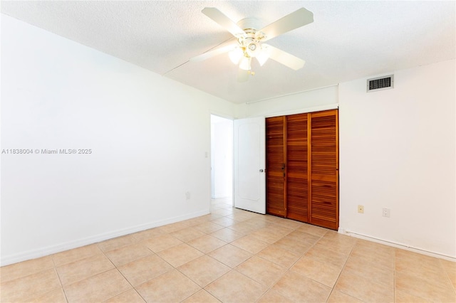 3551 NE 169th St Unit 411, North Miami Beach, FL 33160 - unfurnished bedroom with a closet, light tile patterned floors, ceiling fan, and a textured ceiling