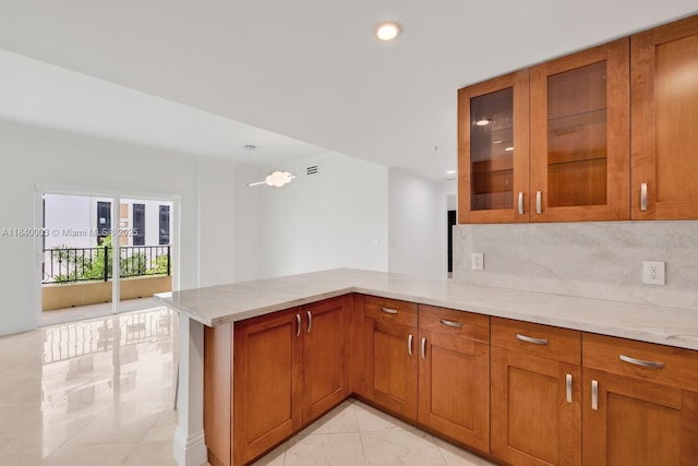 20 Calabria Ave Unit 505, Coral Gables, FL 33134 - kitchen with brown cabinetry, a peninsula, tasteful backsplash, light stone countertops, and recessed lighting