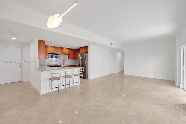 20 Calabria Ave Unit 505, Coral Gables, FL 33134 - kitchen with appliances with stainless steel finishes, open floor plan, a peninsula, light countertops, and backsplash