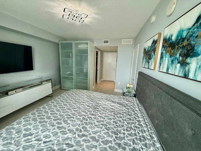 300 Sunny Isles Blvd Unit 4-1806, Sunny Isles Beach, FL 33160 - bedroom with wood finished floors and a textured ceiling