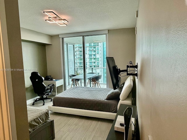 300 Sunny Isles Blvd Unit 4-1806, Sunny Isles Beach, FL 33160 - bedroom featuring wood finished floors, a textured ceiling, a desk, and access to outside