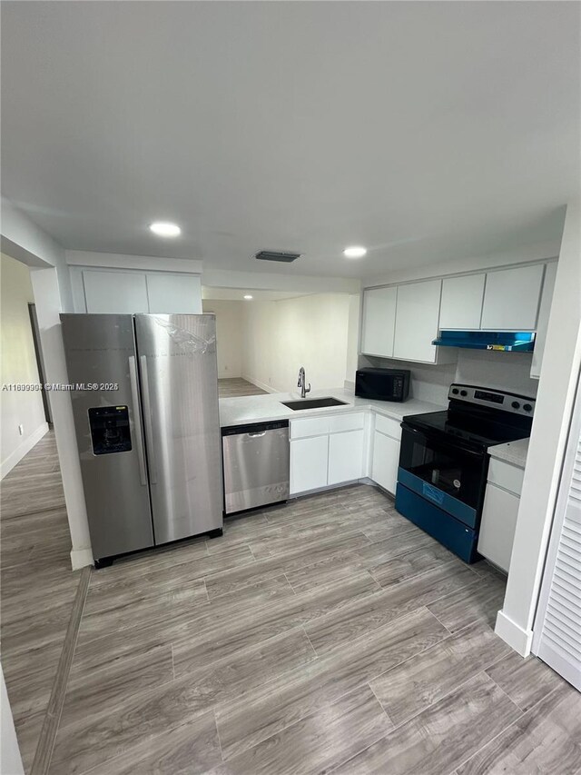 4632 NW 90th Ave, Sunrise, FL 33351 - kitchen with appliances with stainless steel finishes, under cabinet range hood, light countertops, white cabinets, and recessed lighting