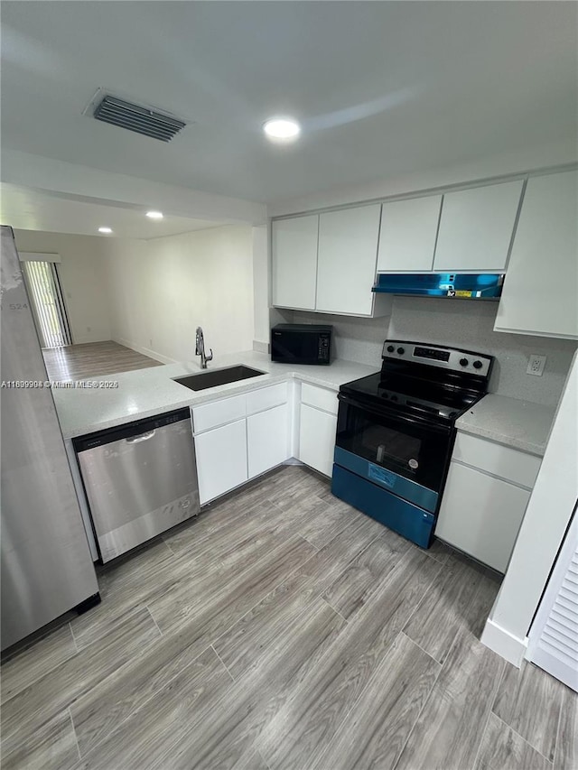 4632 NW 90th Ave, Sunrise, FL 33351 - kitchen featuring black appliances, white cabinets, light countertops, under cabinet range hood, and recessed lighting