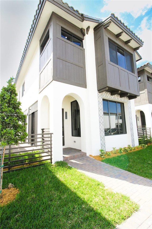 8074 NW 43rd St, Doral, FL 33166 - view of front of house featuring stucco siding, a front lawn, and a tiled roof