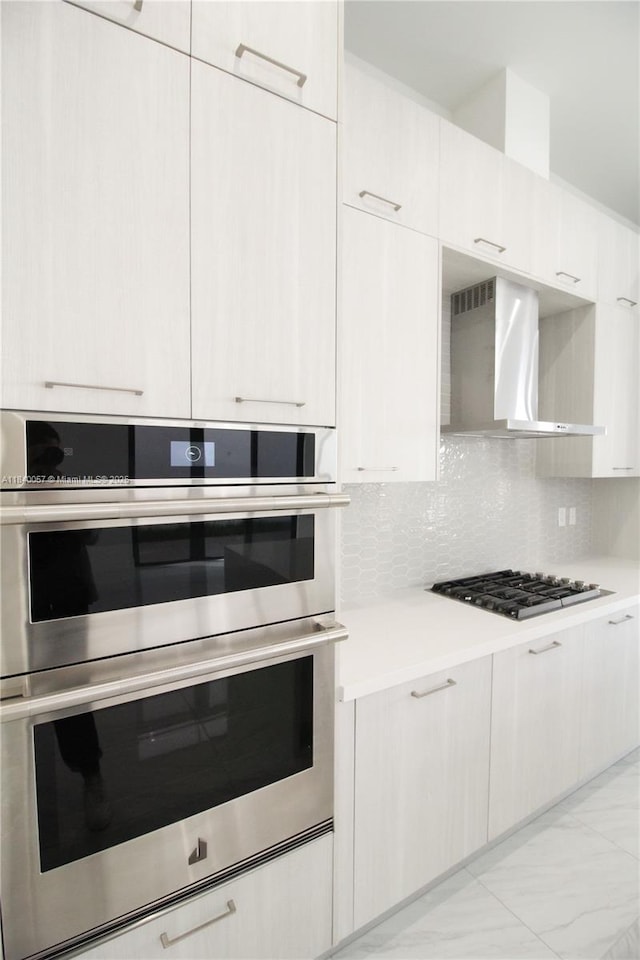 8074 NW 43rd St, Doral, FL 33166 - kitchen featuring stainless steel appliances, wall chimney range hood, light countertops, light marble finish floors, and tasteful backsplash