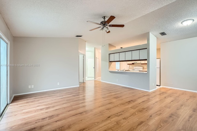 10897 Grandview Ct, Royal Palm Beach, FL 33411 - unfurnished living room with vaulted ceiling, a ceiling fan, a textured ceiling, light wood-style floors, and healthy amount of natural light