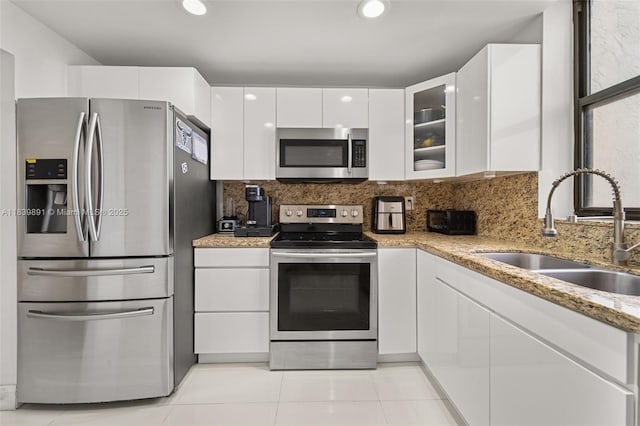 18181 NE 31st Ct Unit 1401, Aventura, FL 33160 - kitchen featuring appliances with stainless steel finishes, white cabinetry, modern cabinets, tasteful backsplash, and light stone counters