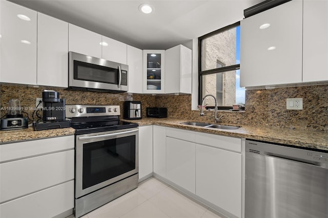 18181 NE 31st Ct Unit 1401, Aventura, FL 33160 - kitchen featuring appliances with stainless steel finishes, light stone countertops, and white cabinetry