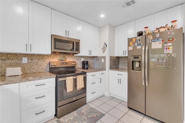 18030 SW 153rd Ct, Miami, FL 33187 - kitchen with stainless steel appliances, light tile patterned flooring, decorative backsplash, white cabinets, and recessed lighting