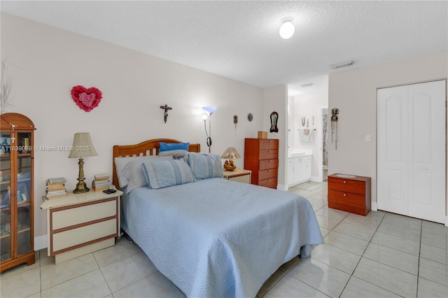18030 SW 153rd Ct, Miami, FL 33187 - bedroom with light tile patterned flooring, a textured ceiling, ensuite bath, and a closet