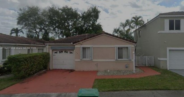 16907 SW 142nd Pl, Miami, FL 33177 - view of front facade with an attached garage, stucco siding, driveway, and a tile roof